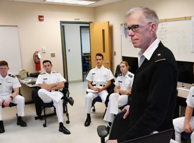 Brigadier General Jeff Smith stands in front of the cadets in his history of information technology class.